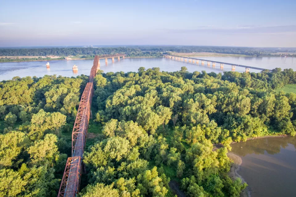 Two bridges cross the Mississippi Rivera midst thick vegetation and few other signs of human intervention.